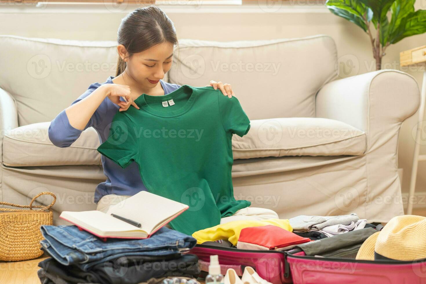 Backpacker travel of journey, asian young woman, packing or prepare clothes into luggage, traveler case for journey trip, note and check list for holiday vacation at home. Voyage of traveler people. photo