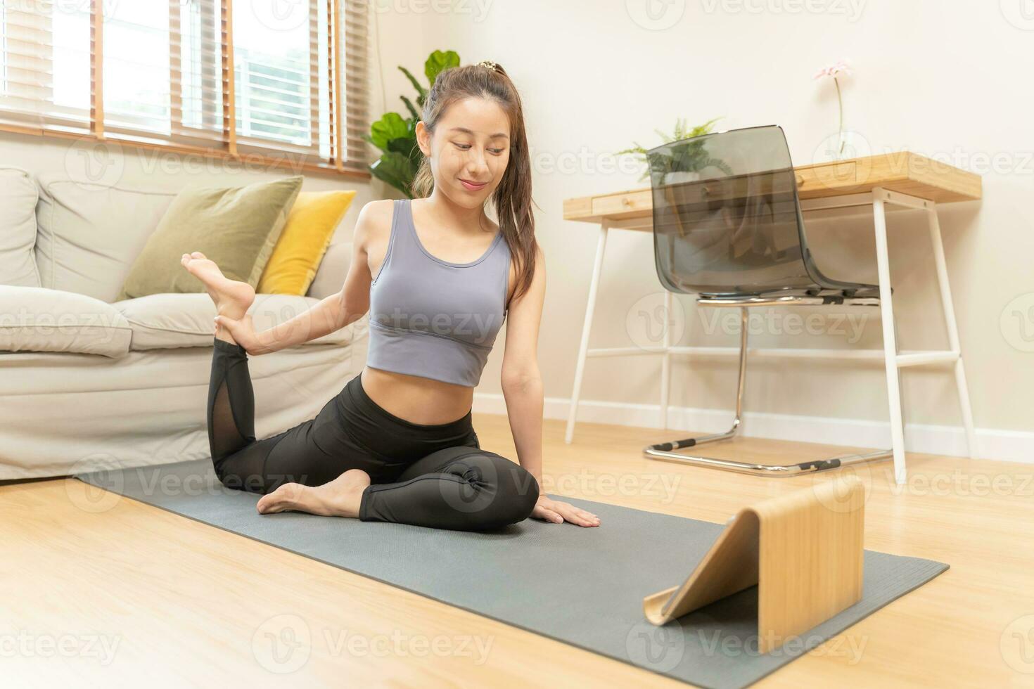 adaptar, deportivo asiático joven mujer en ropa de deporte sentado en piso, ejercicio en estera, acecho en línea formación videos en tableta en vivo habitación a hogar. rutina de ejercicio aptitud física, pilates para bienestar, sano cuidado. foto