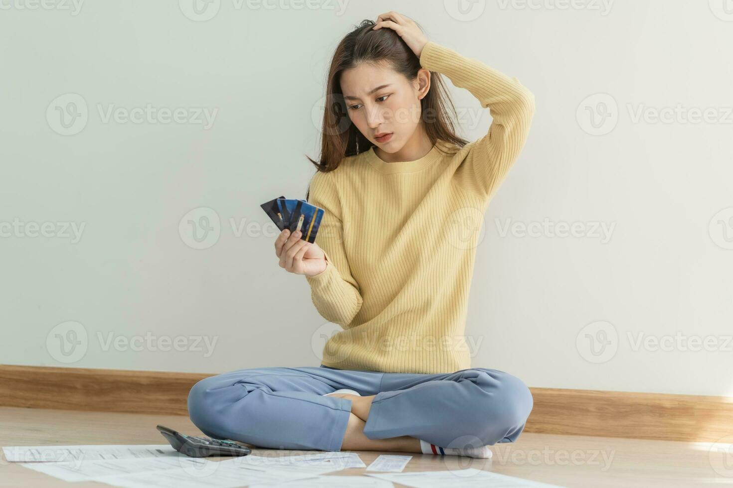 Financial owe asian woman, female sitting on floor home, stressed and confused by calculate expense from invoice or bill, have no money to pay, mortgage or loan. Debt, bankruptcy or bankrupt concept. photo