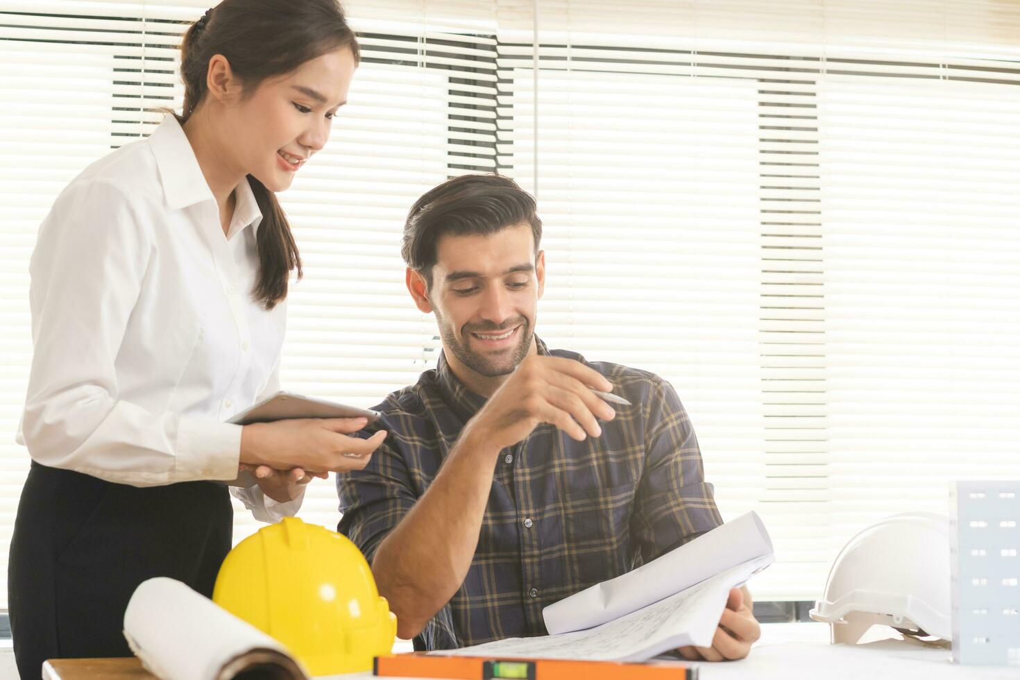 Construction of Engineer, architect businessman, woman making on blueprint of house building in office together, meeting plan working with partner team colleagues on blueprint, discussing design. photo