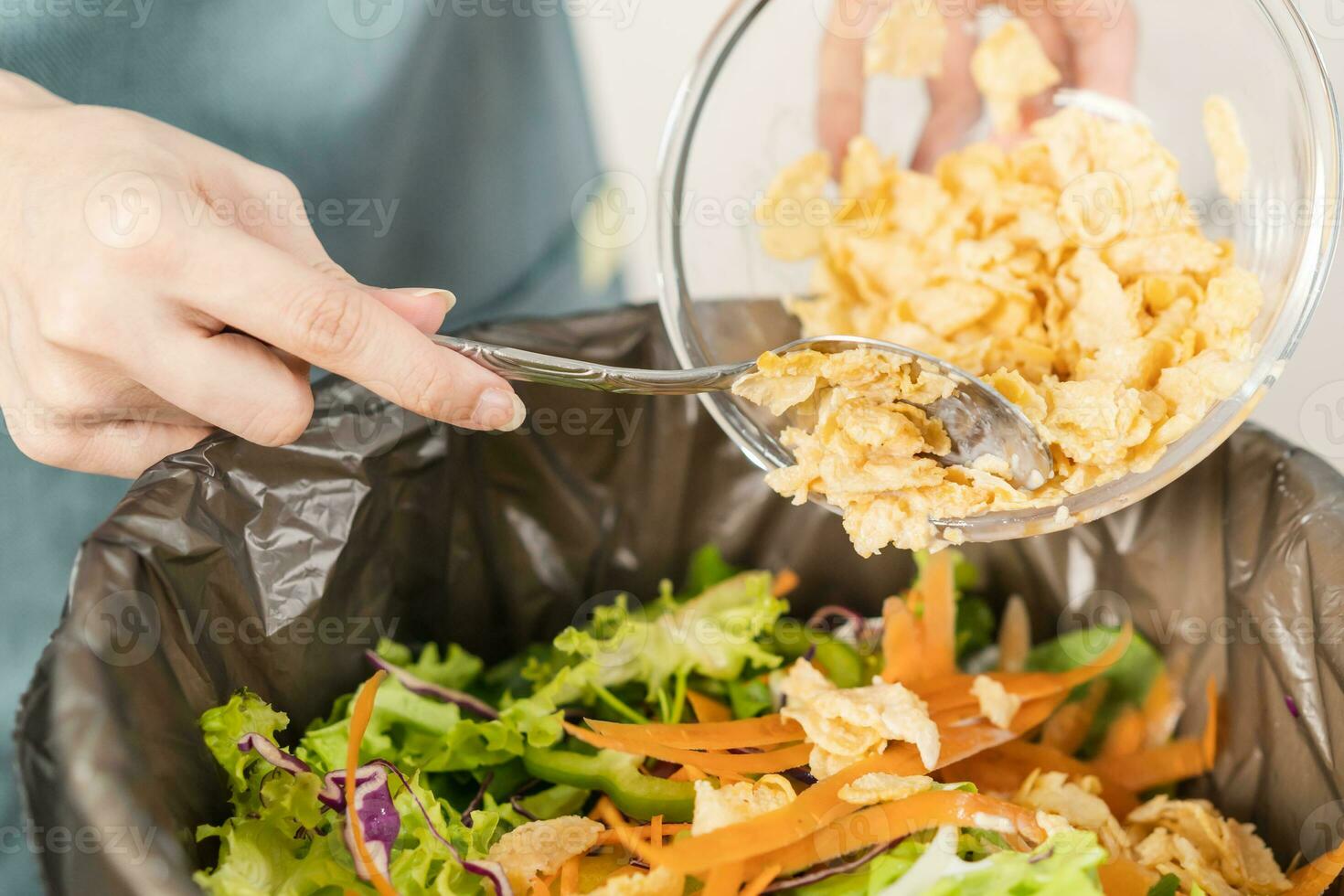 Compost the kitchen waste, recycling, organic meal asian young household woman scraping, throwing food leftovers into the garbage, trash bin from vegetable. Environmentally responsible, ecology. photo