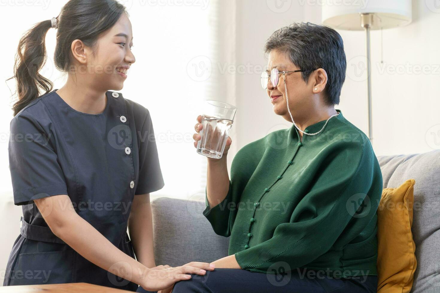 asiático joven mujer cuidador, cuidador secundario anciano, Envejecido paciente a hogar, Bebiendo agua después tomar medicamento, cura o tratamiento enfermedad de abuela después Jubilación, ayuda apoyo. foto