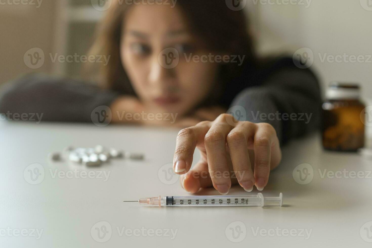 Anti drug, drug addict asian young woman, girl hand reaching for syringe, medicament with narcotic on table at home, abuse overdose. Sick pain of health, unhealthy people. Suicide depressed or despair photo