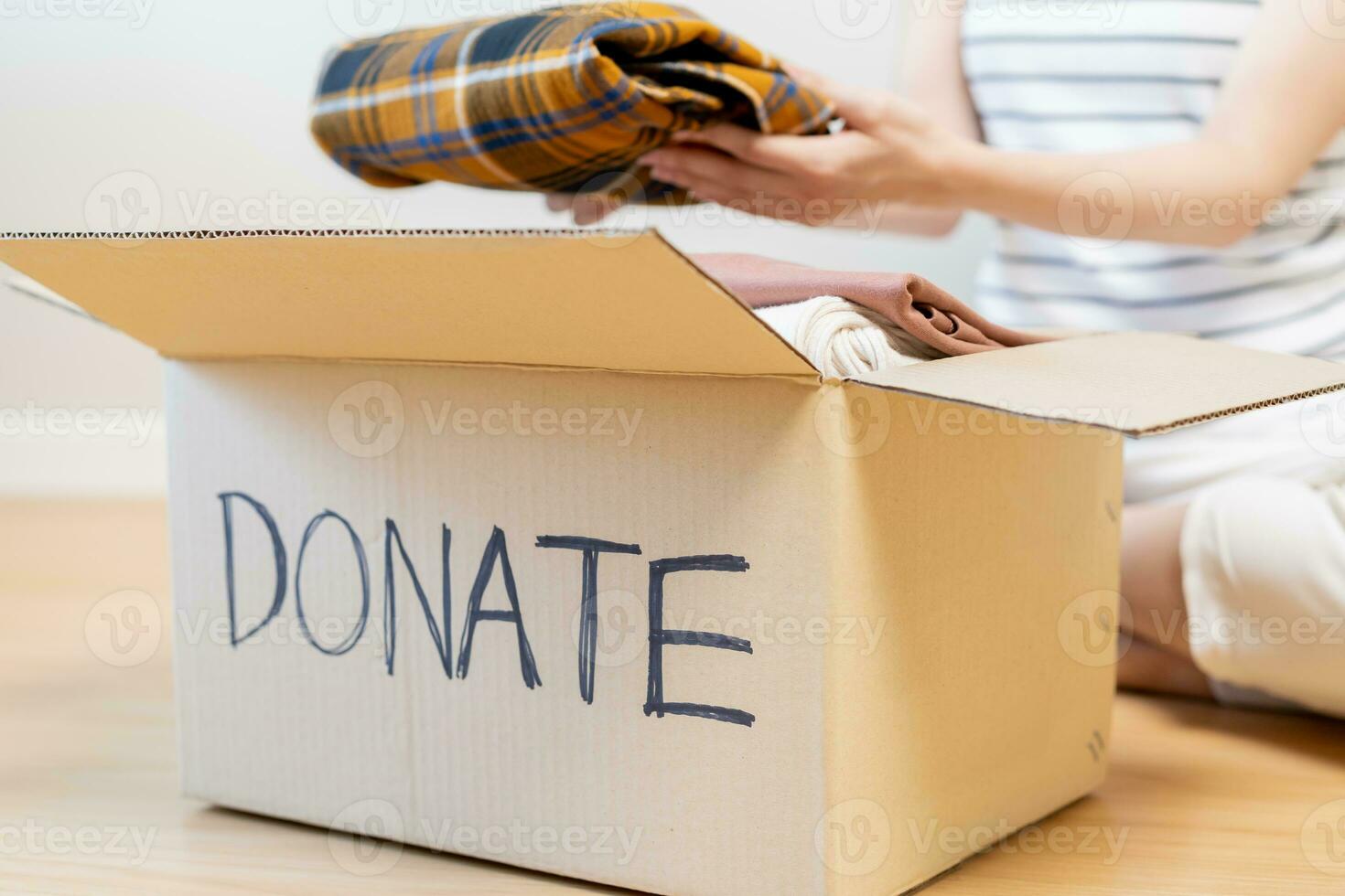 Recycling, Donation for poor, asian young woman, girl sitting pack on floor at home, put on stuff into donate box with second hand clothes, charity helping and needy people. Reuse recycle, moving. photo