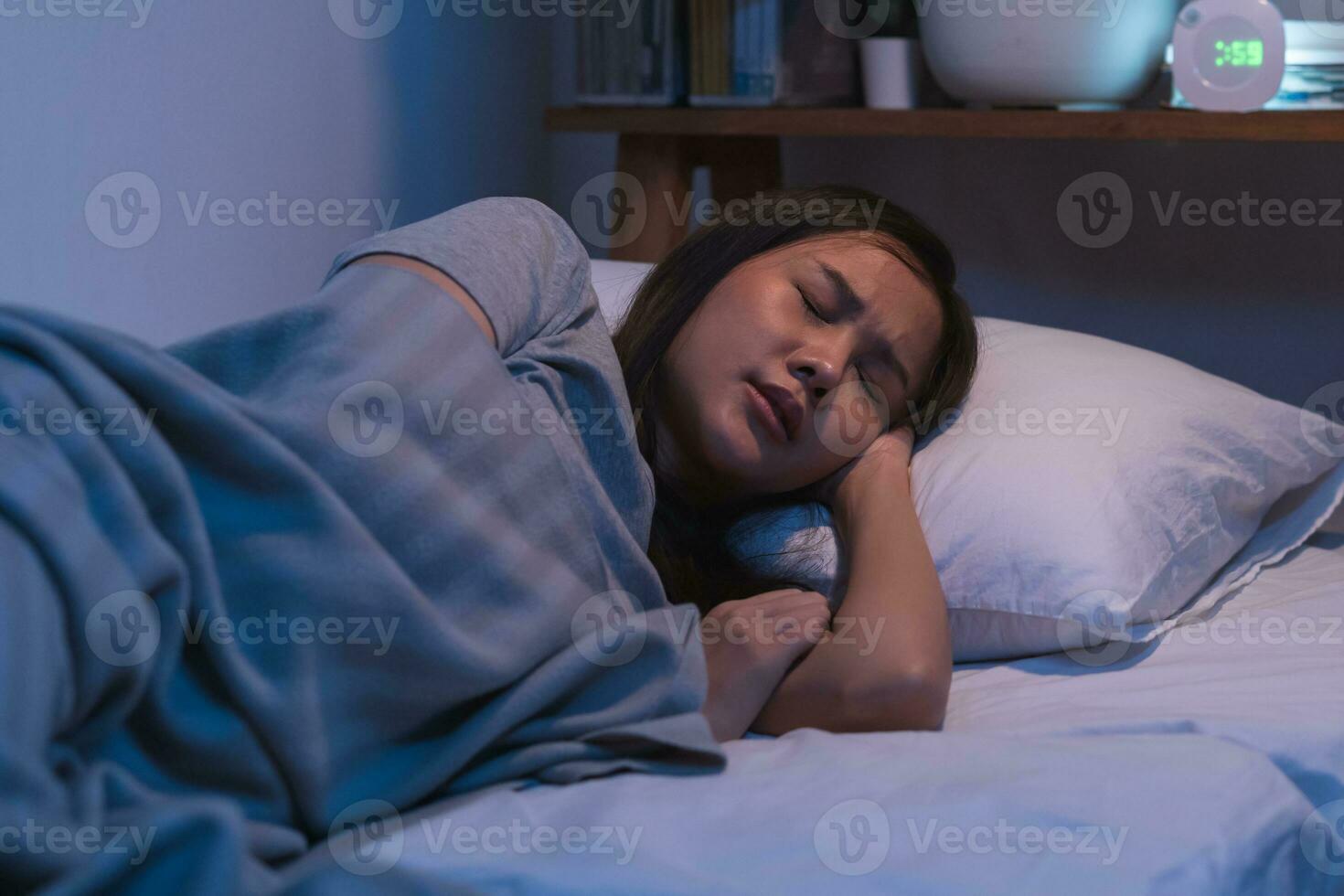 sufrimiento de dormido. dormir asiático joven mujer, niña debajo frazada, sufrimiento desde insomnio, despierto a noche en dormitorio, cansado y exhausto. frustrado personas con problema, agotado en pesadillas foto