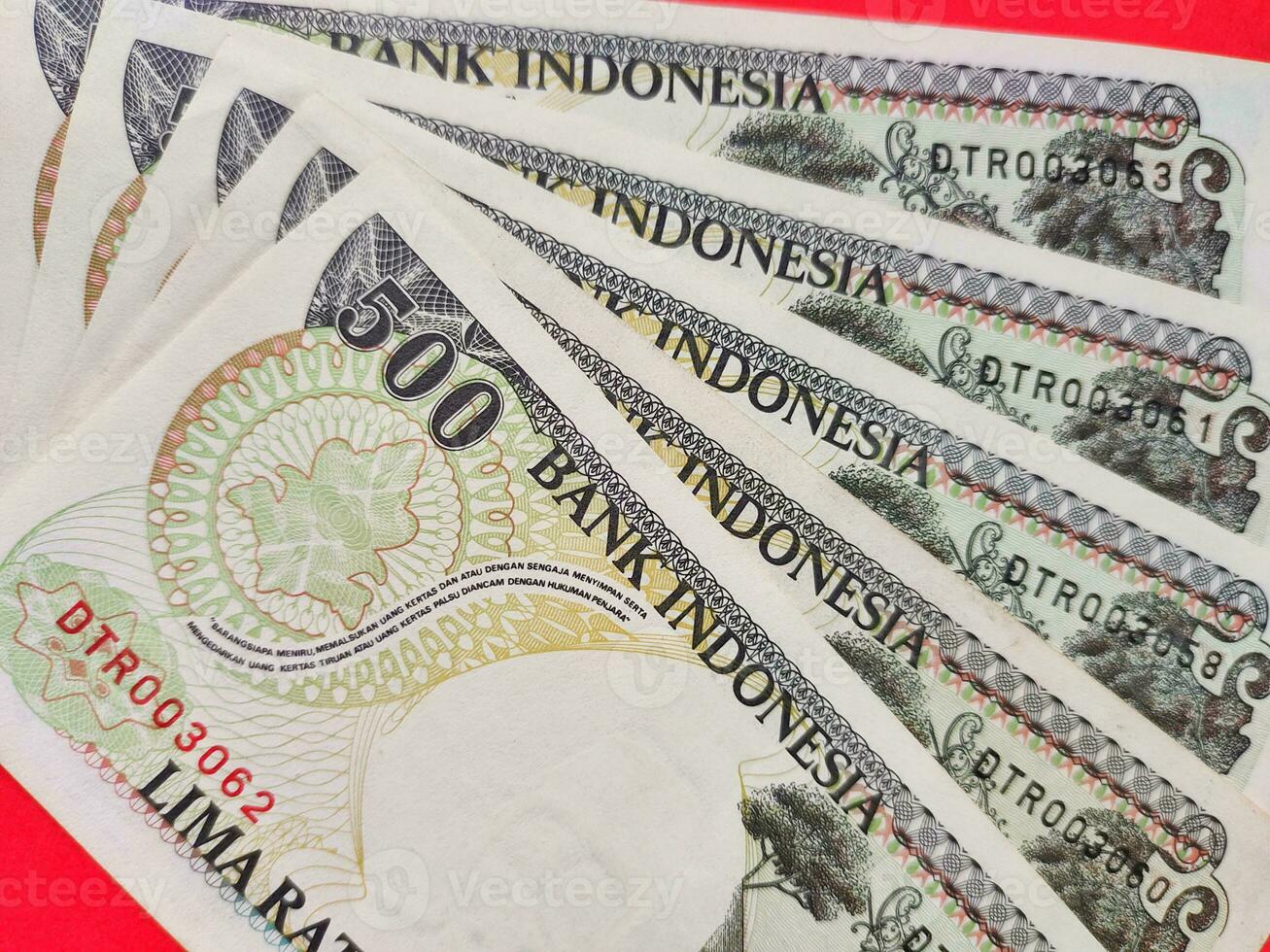 Top view of old Indonesian banknotes Rp.500,00 issued in 1992. Rupiah currency concept isolated on a red background. photo