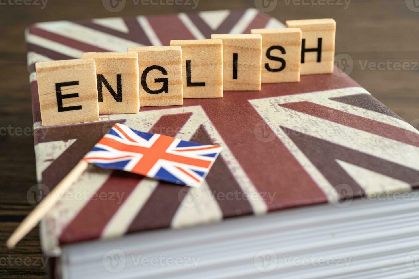 Word English on book with United Kingdom flag, learning English language courses concept. photo