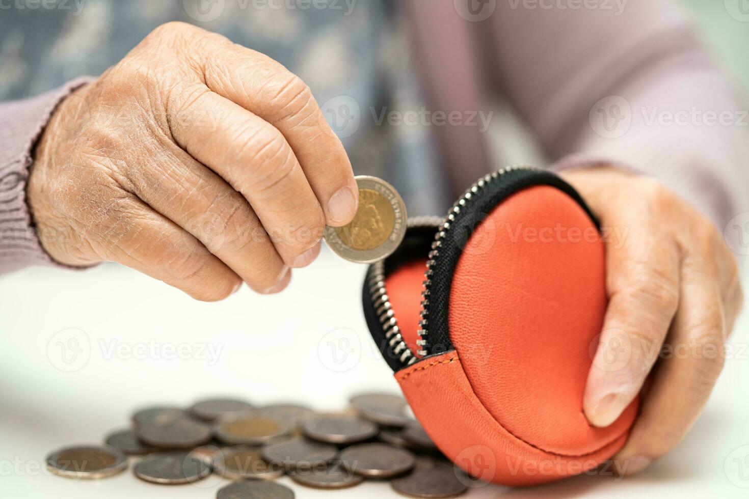 Asian senior woman holding counting coin money in purse. Poverty, saving problem in retirement. photo