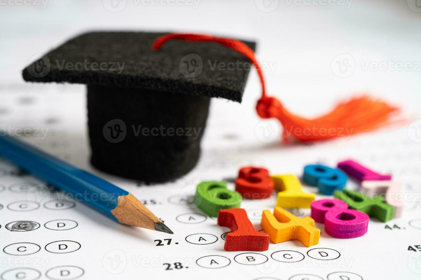 Graduation gap hat and pencil on answer sheet background  Education study testing learning teach photo