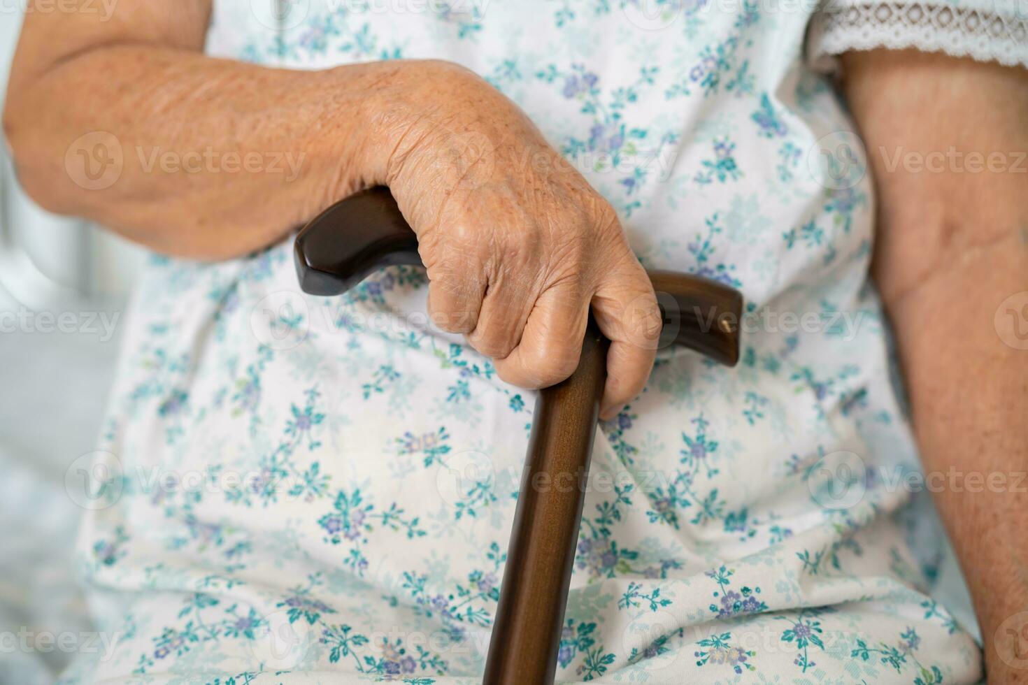 Asian elderly disability woman holding waling stick, wood cane, round handle, walking aid for help to walk. photo