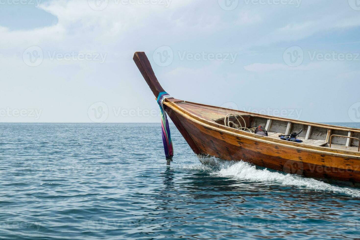 Long tail wooden boat sail on sea photo