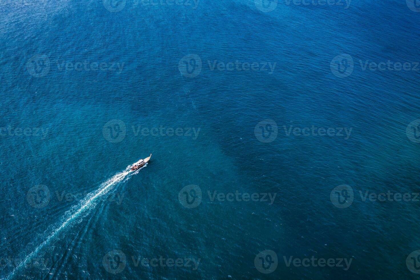 Traditional wooden boat sailing in tropical blue sea on summer photo