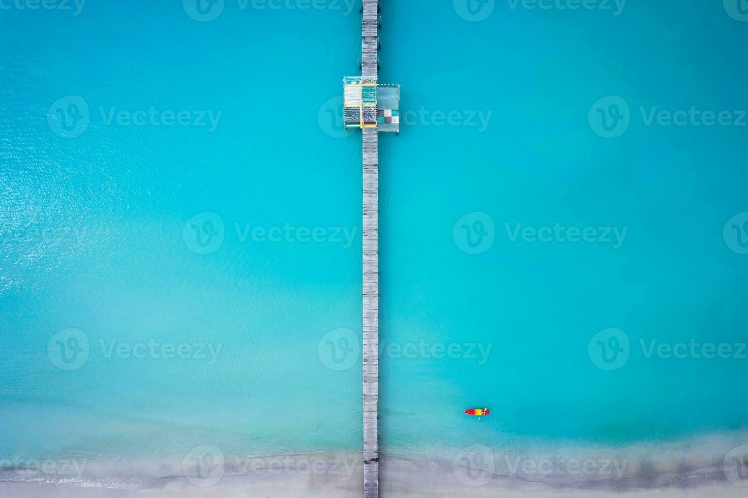 Tourist canoeing by wooden pier in turquoise sea and the beach on summer at tropical island photo
