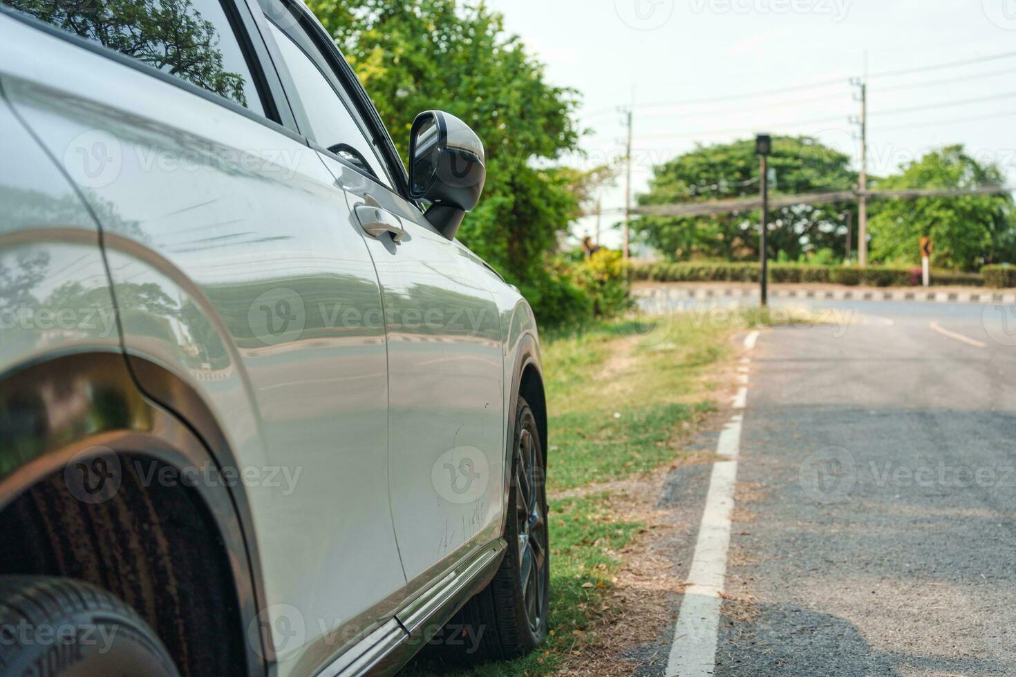 White modern SUV car with stain asphalt parked on roadside photo