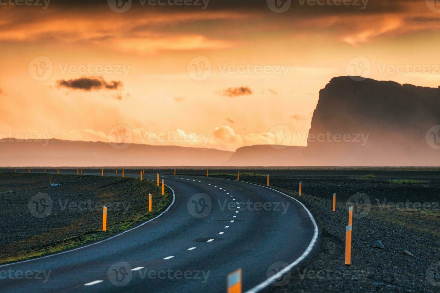 Scenic curved highway asphalt road with golden sky and mountain in the sunset photo