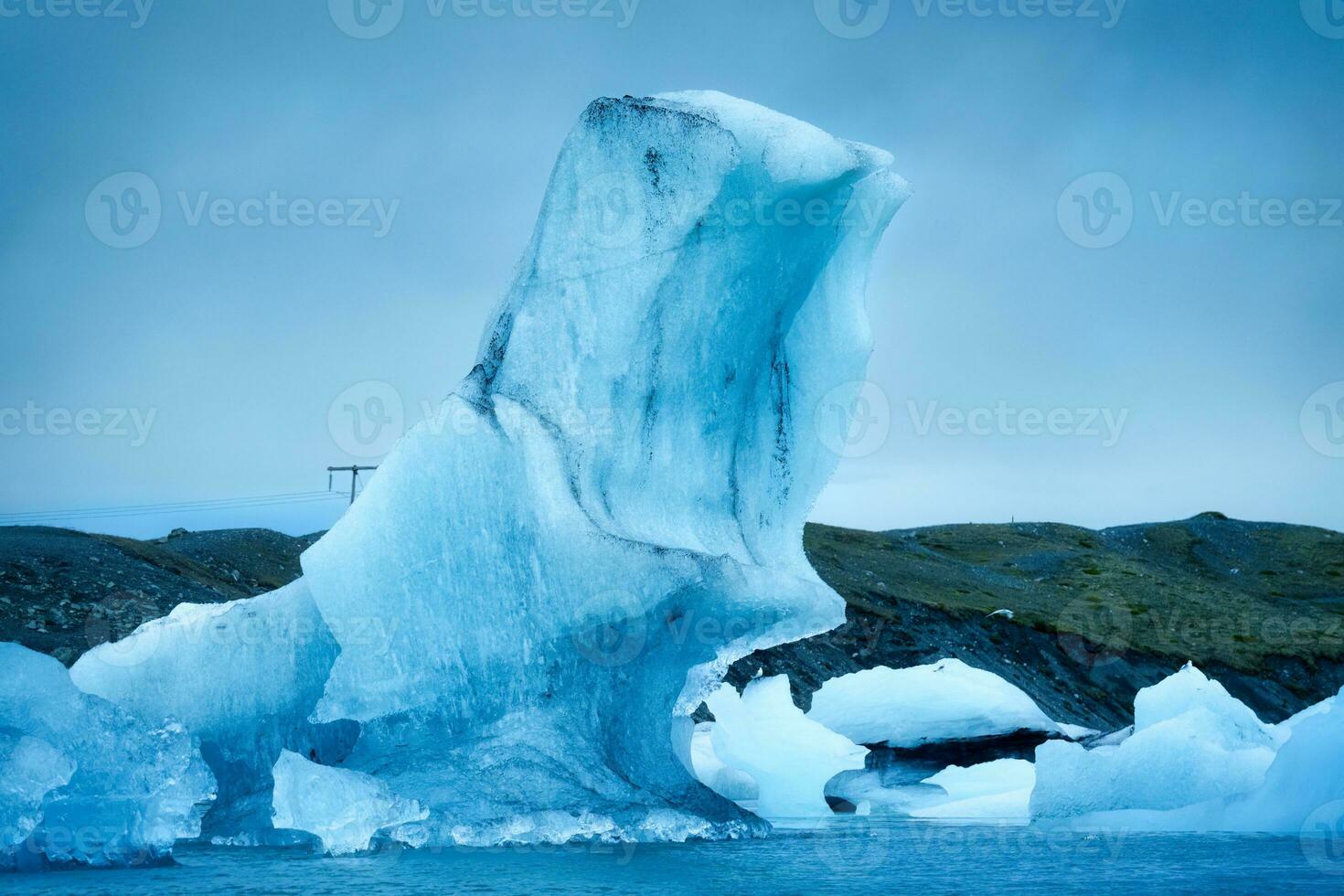 Natural blue iceberg floating and melting in Jokulsarlon glacier lagoon photo