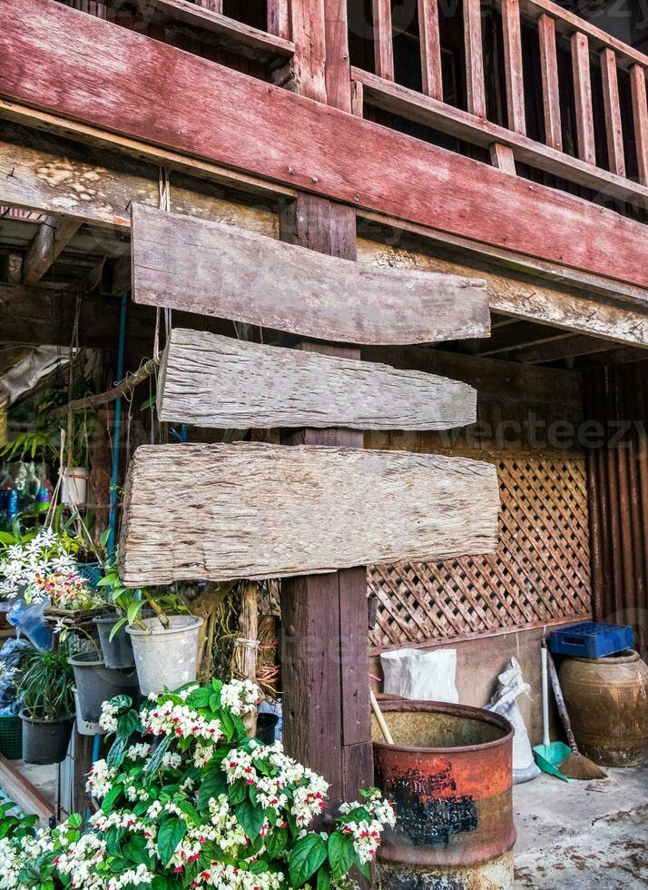 Weathered wooden signboard with flower decoration in rural photo