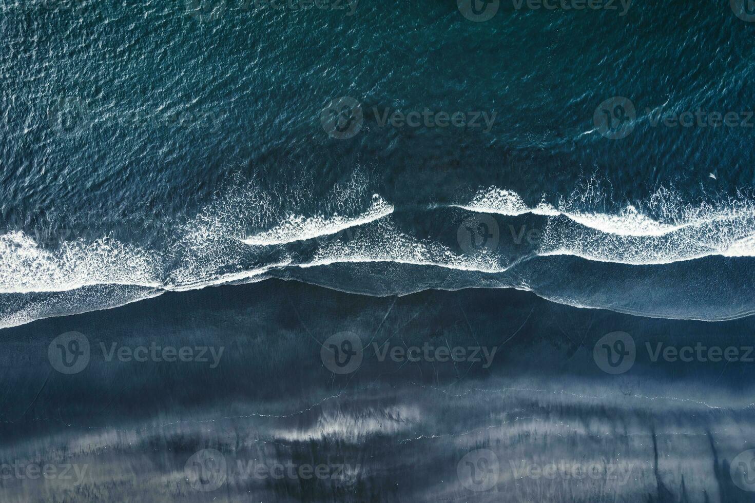 Moody atlantic ocean wave on black sand beach in summer at Iceland photo