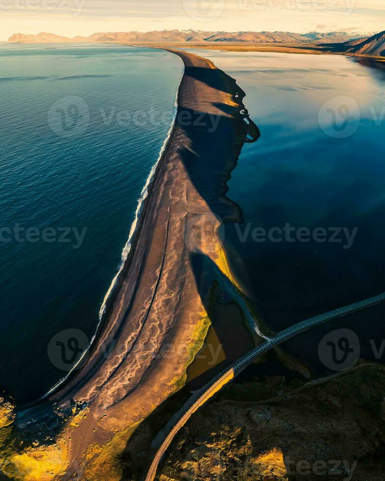 Beautiful sunrise over volcanic mountain range in rural scene by the ocean of peninsula at summer in Iceland photo