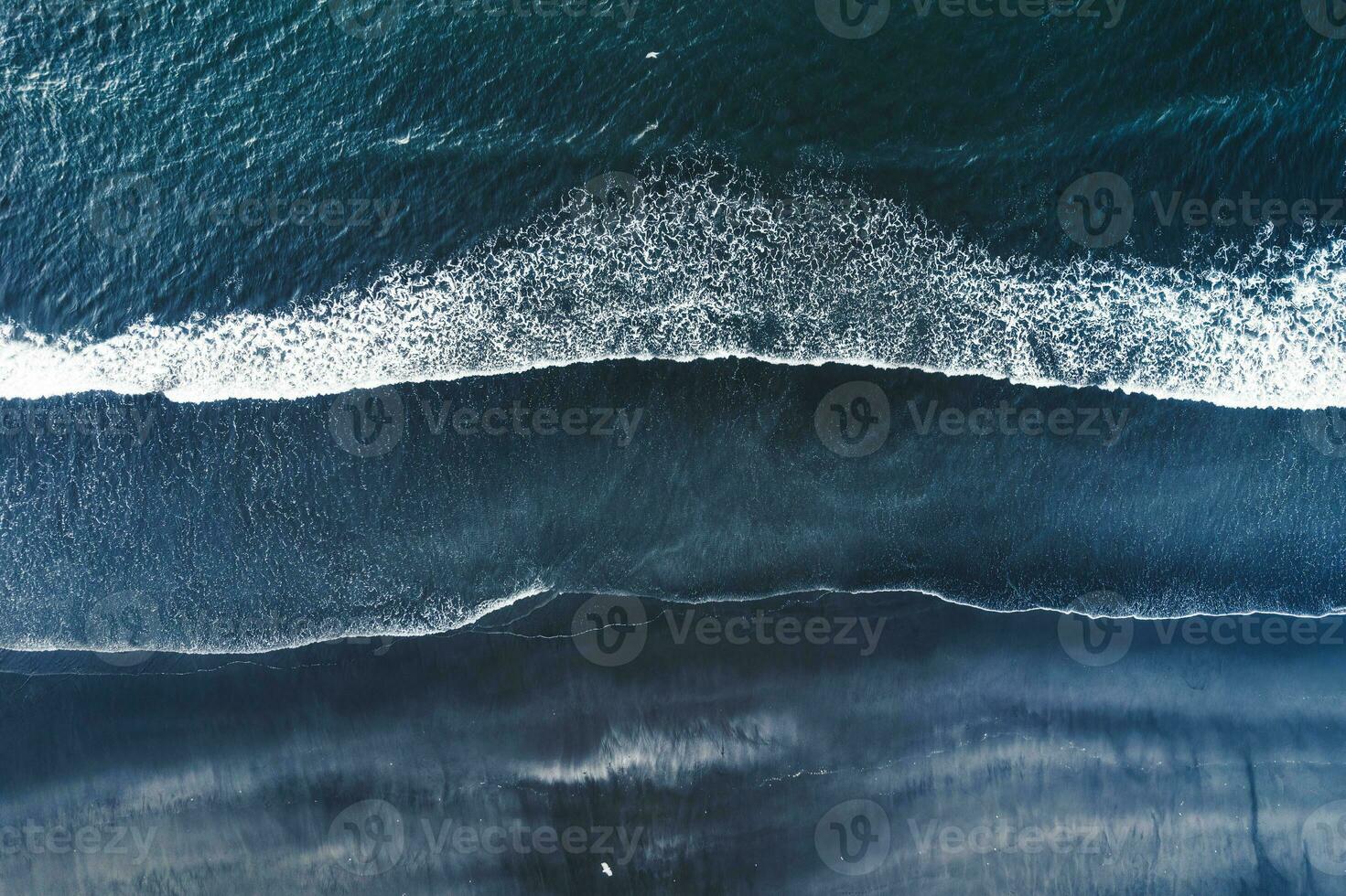 Moody atlantic ocean wave on black sand beach in summer at Iceland photo