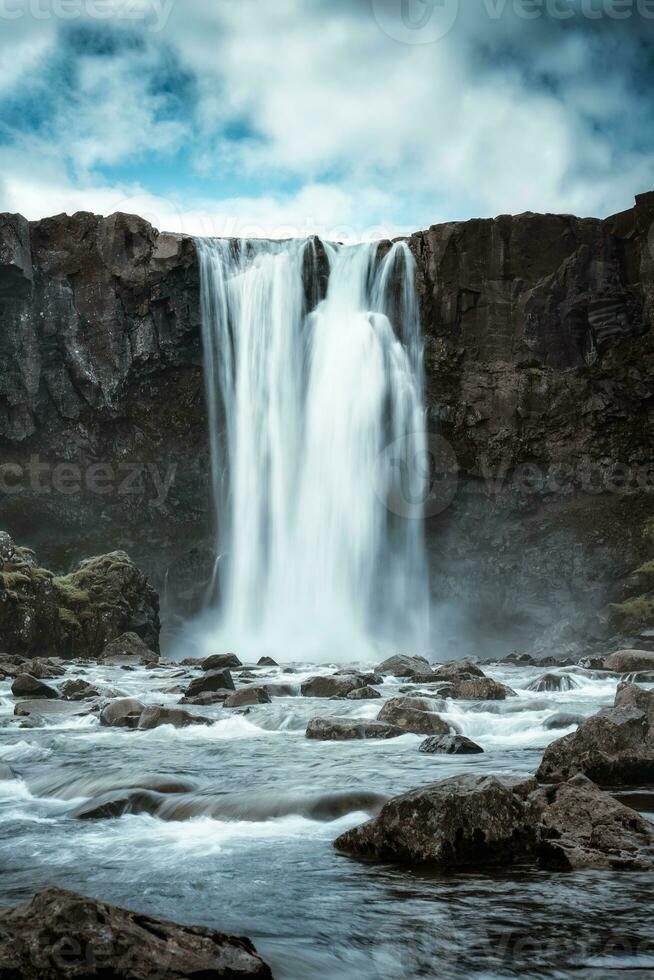 Moody Gufufoss waterfall flowing on summer in east fjords photo