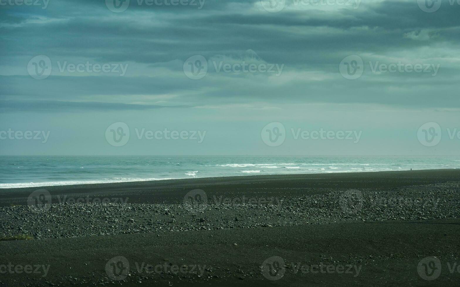 Moody of Atlantic sea with black sand beach in remote wilderness photo