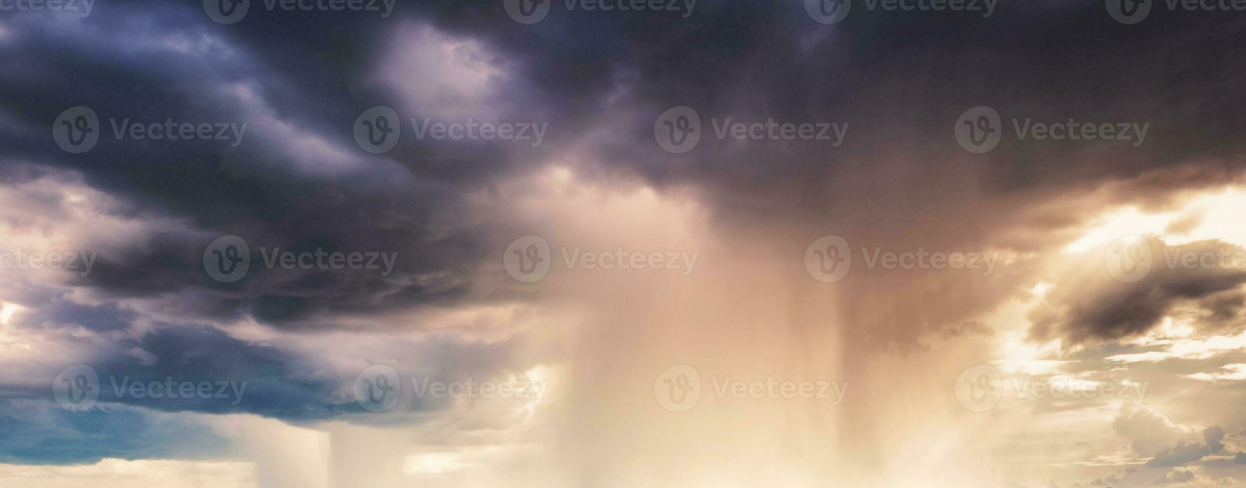 Heavy rainstorm in colorful stormy sky at evening photo