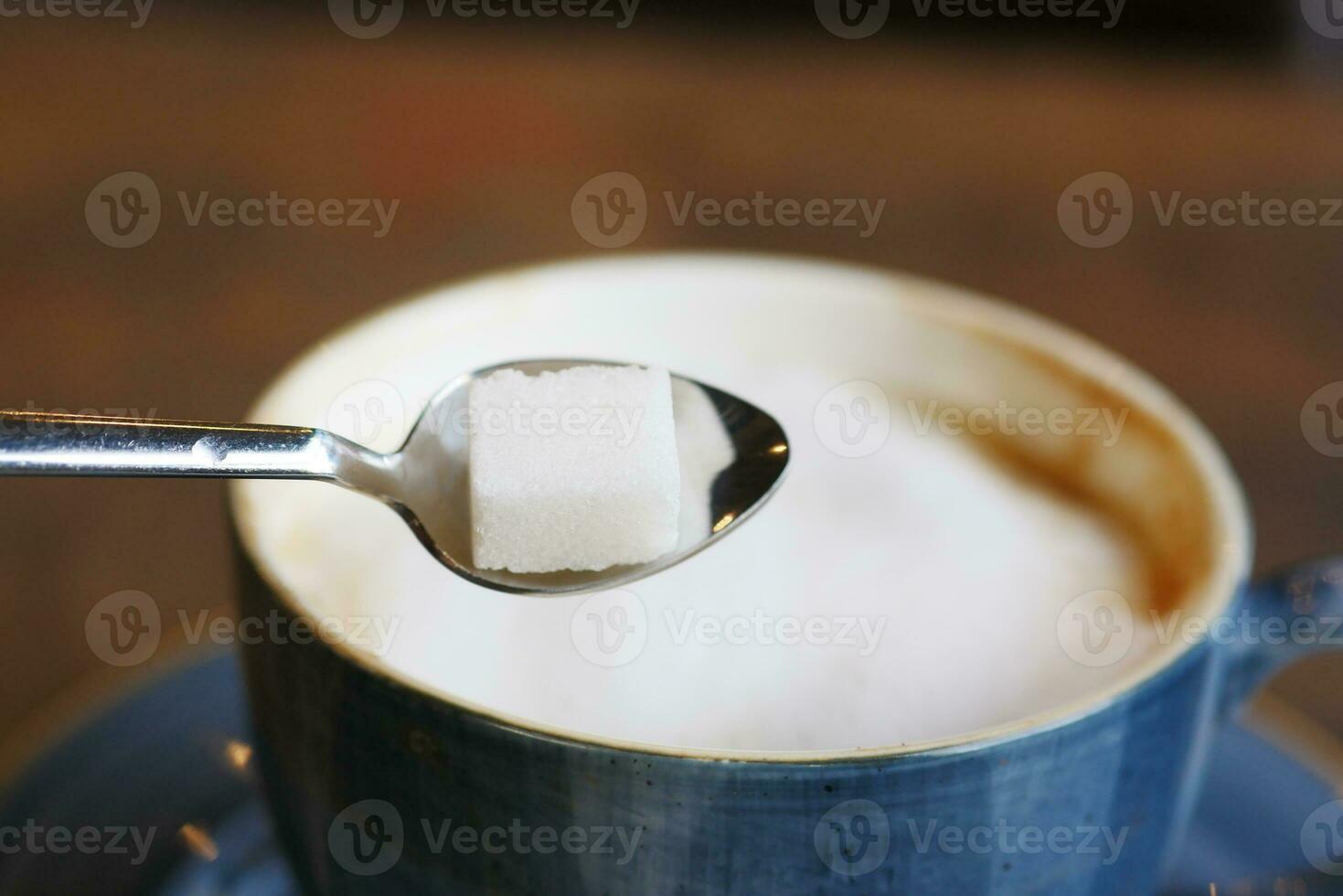 cup of tea and sugar cube on table photo