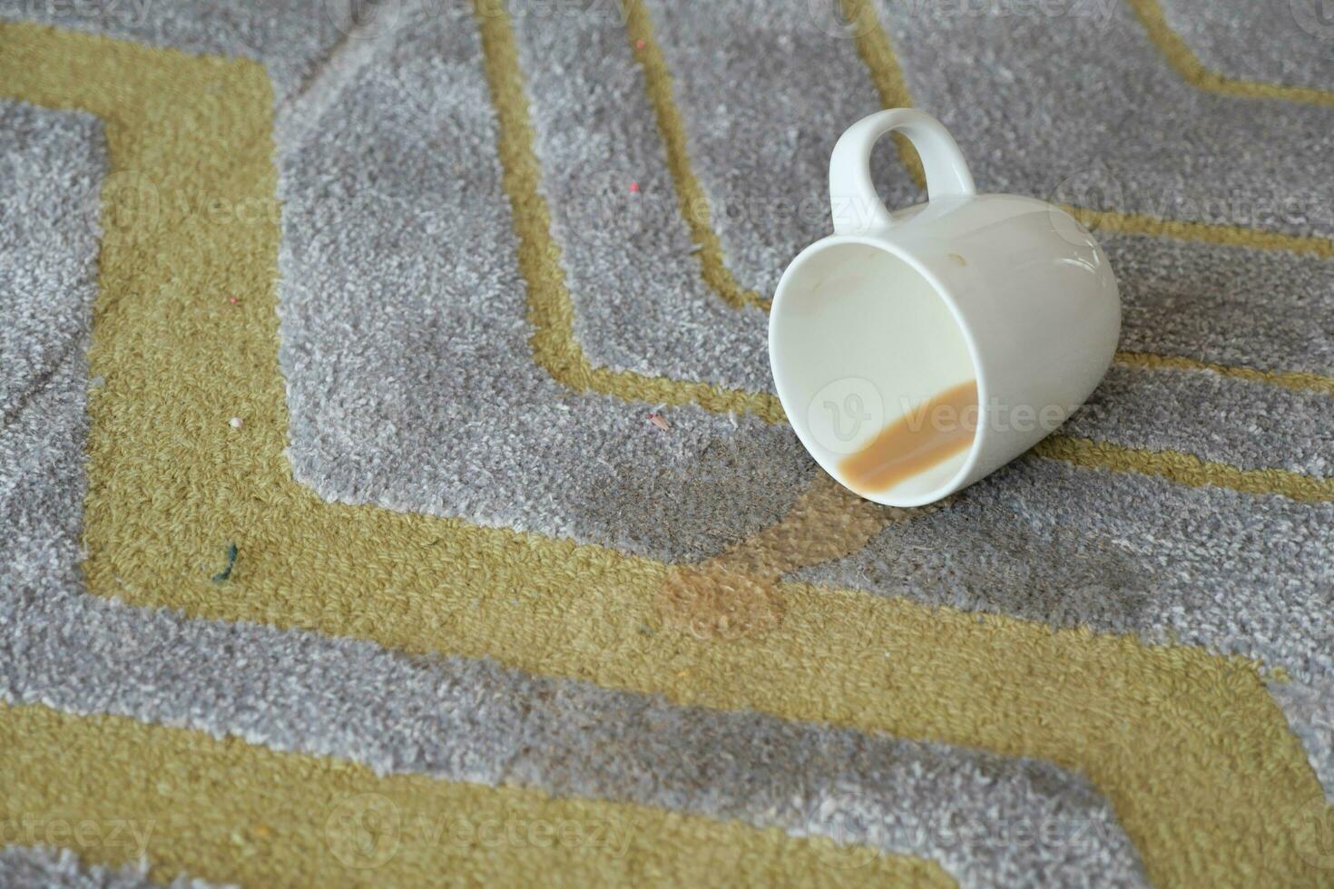 cup of coffee spilled on gray color carpet photo