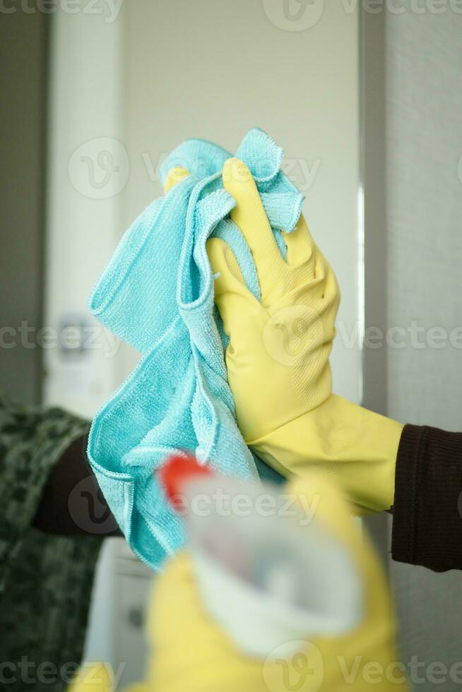 primer plano de la mano de la persona en guantes limpiando el cristal de la ventana foto