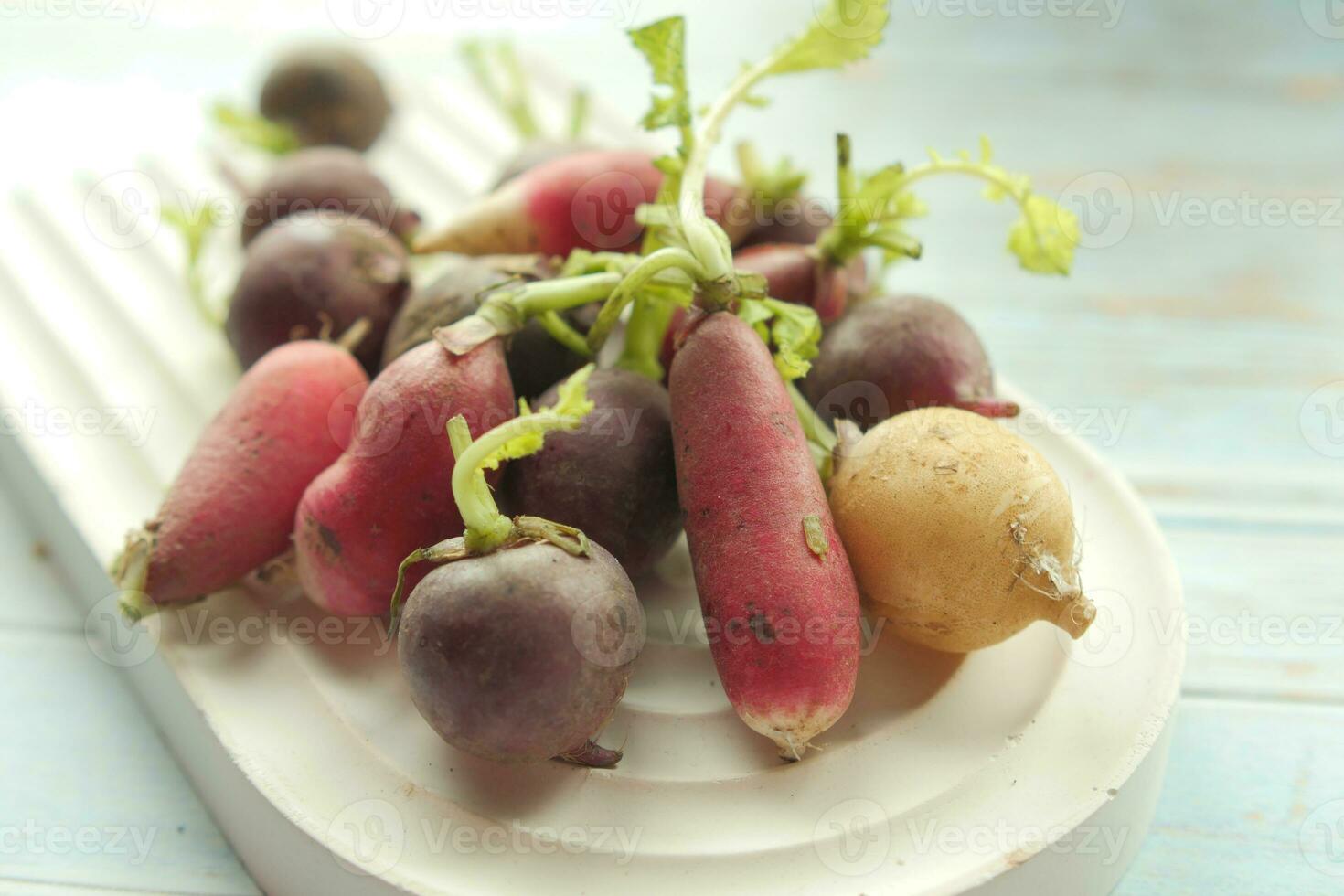 Fresh red radish bundle on chopping board on table photo