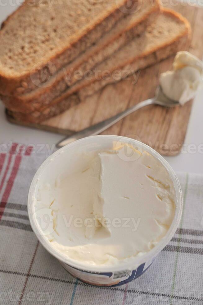 rebanada de un pan y crema queso en blanco antecedentes. foto