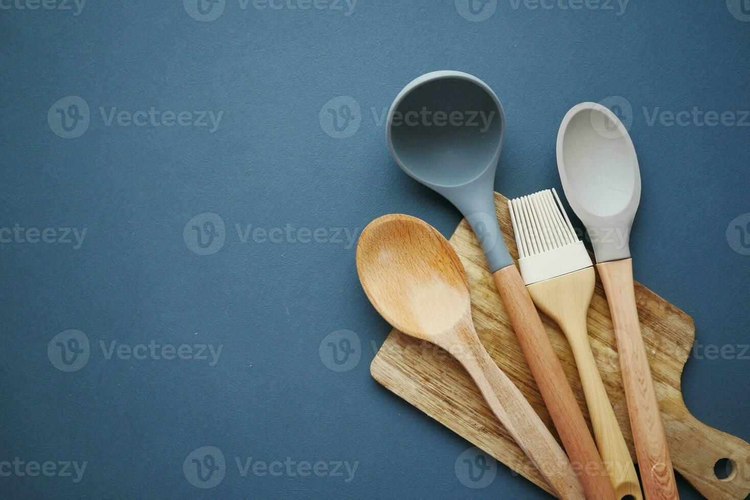 wooden cutlery forks and a chopping board on black color background photo