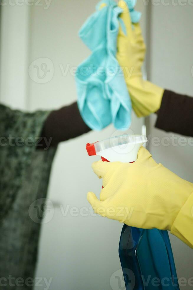 primer plano de la mano de la persona en guantes limpiando el cristal de la ventana foto