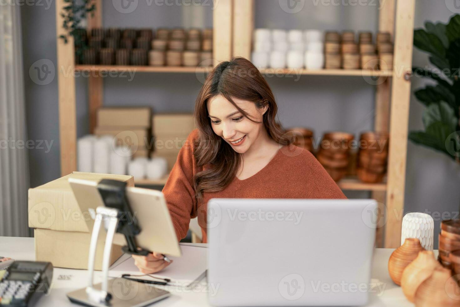 Vase brand owner processes online orders. Response to customer queries and concerns about products and shipment to increase long term loyalty and satisfaction. Routine work of e commerce entrepreneur photo