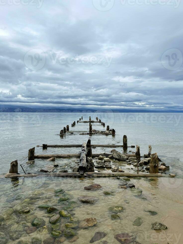 Old ruined pier on the shore of Lake Baikal, Olkhon, Russia photo