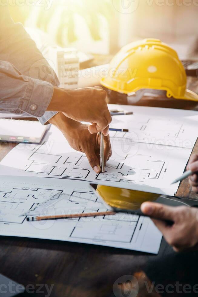 concepto de construcción y estructura de reunión de ingenieros o arquitectos para el proyecto que trabaja con socios y herramientas de ingeniería en la construcción de modelos y planos en el lugar de trabajo, contrato para ambas empresas. foto