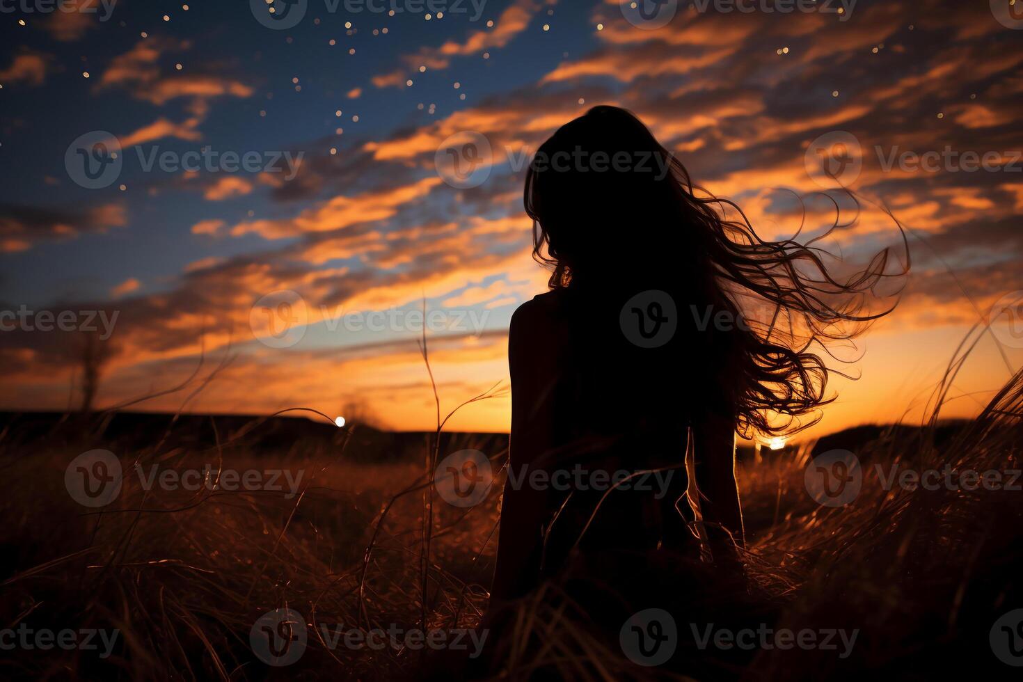 Silhoutte of girl looking into space on a field. photo