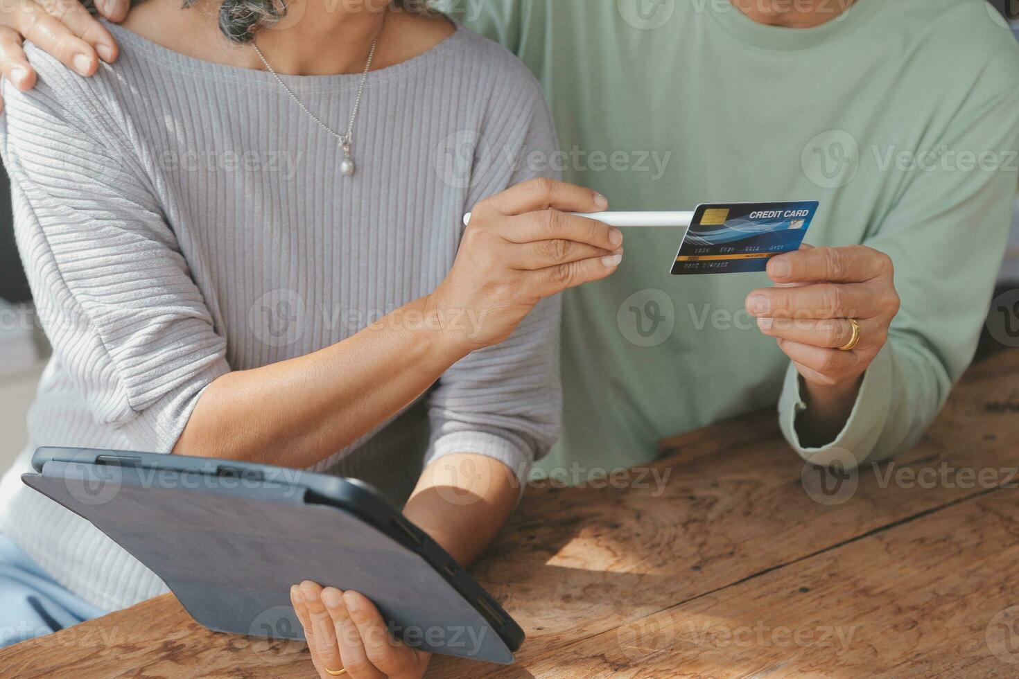 Close up mature man holding plastic credit card, senior couple family paying online, using laptop, satisfied older customers making secure internet payment, shopping, browsing banking service photo