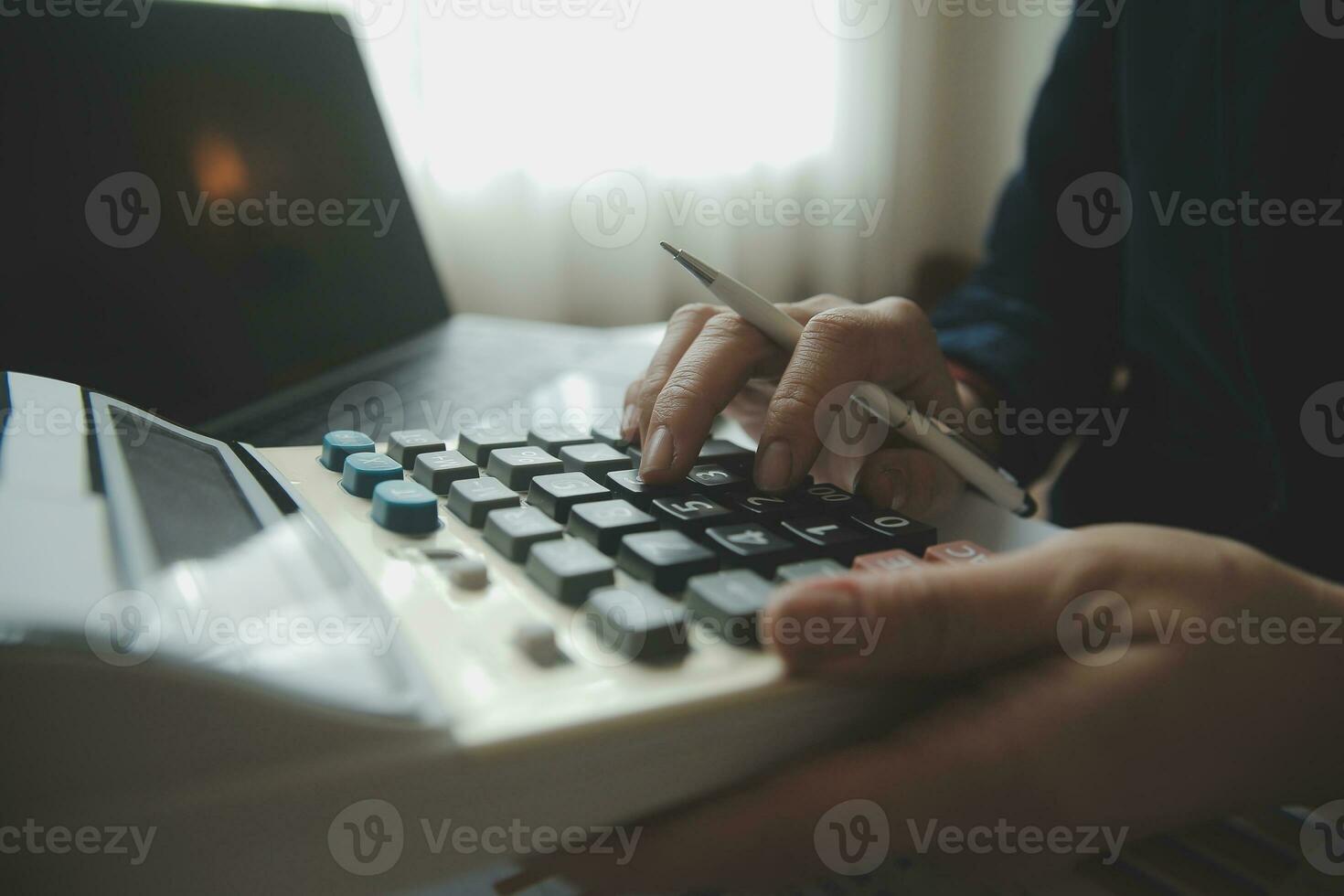 Close up businessman hand using calculator and working with laptop calculate about finance accounting at coffeeshop outdor.finance accounting concept photo
