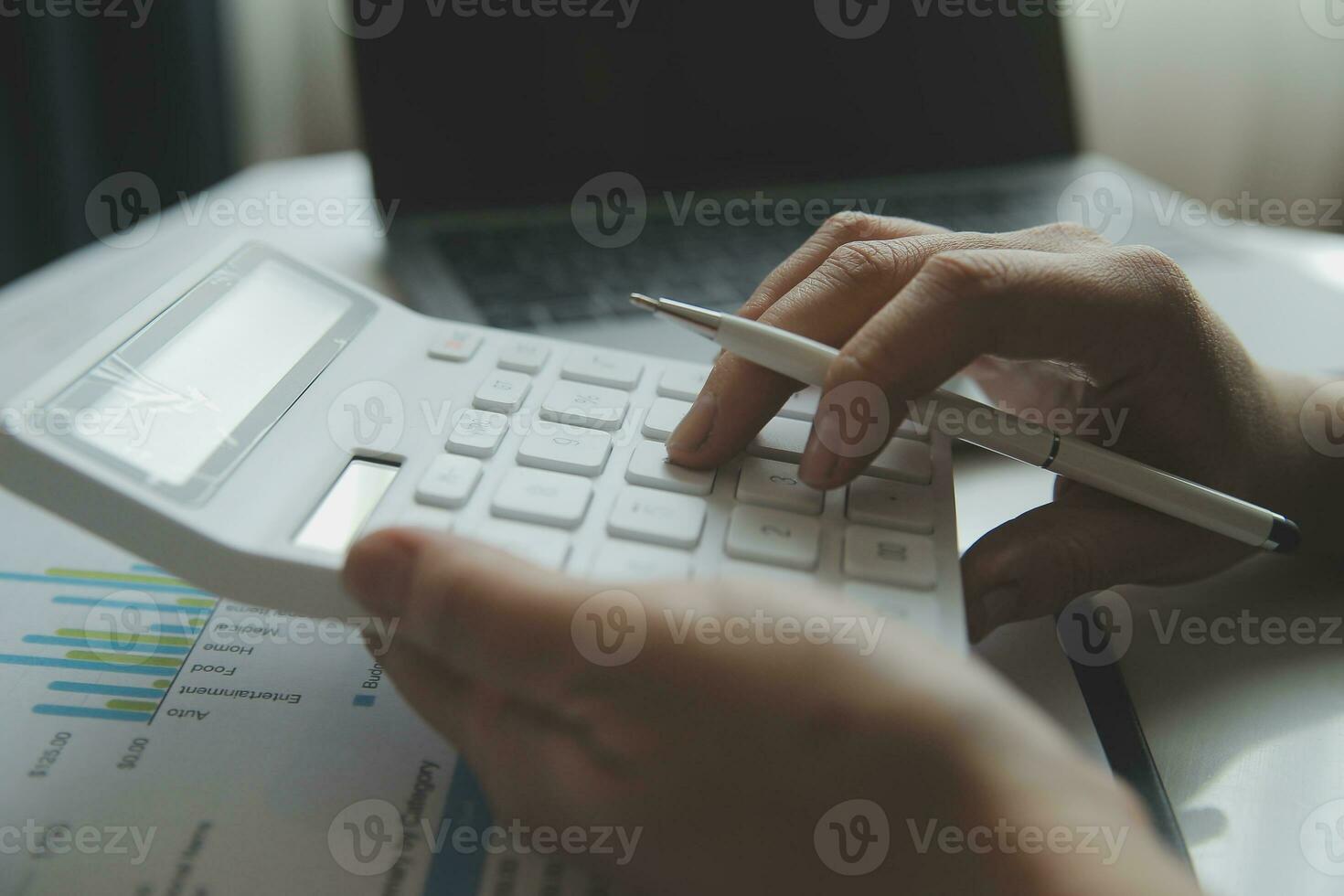 Close up businessman hand using calculator and working with laptop calculate about finance accounting at coffeeshop outdor.finance accounting concept photo