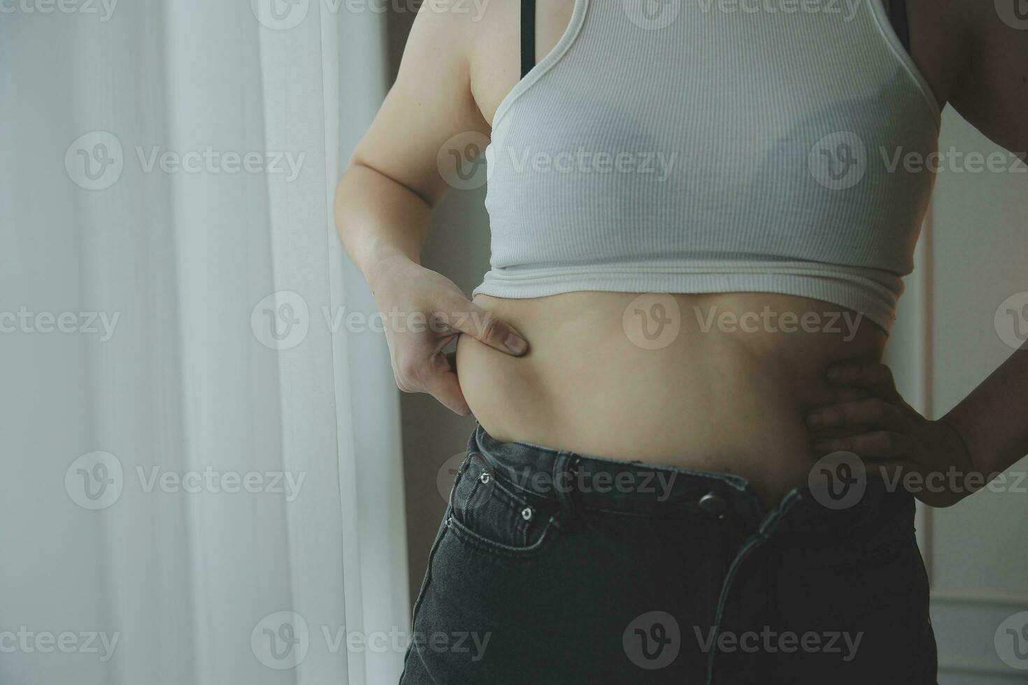 mujer gorda, barriga gorda, gordita, mujer obesa mano sosteniendo grasa abdominal excesiva con cinta métrica, concepto de estilo de vida de dieta de mujer foto