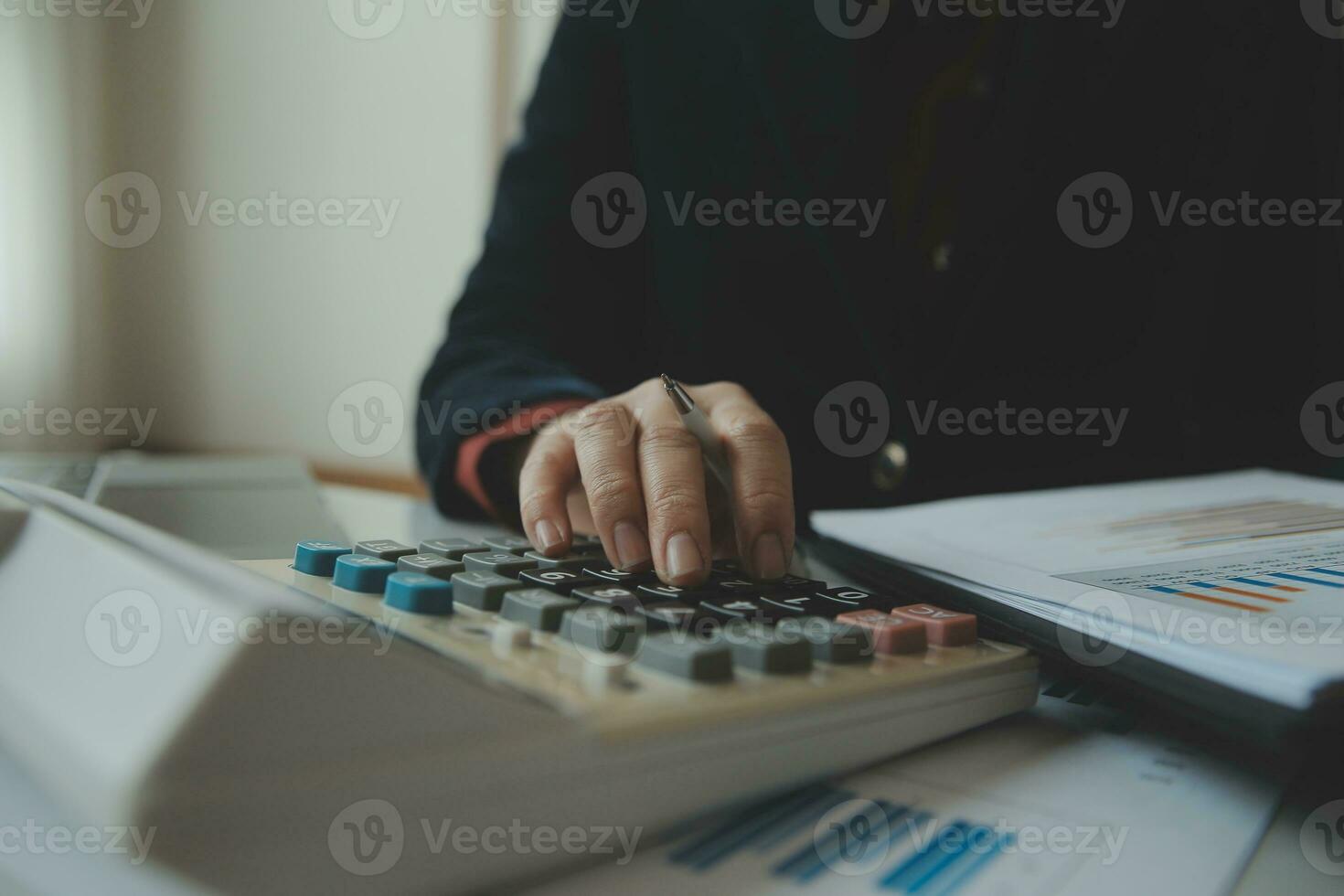 Unrecognizable businessman using calculator photo