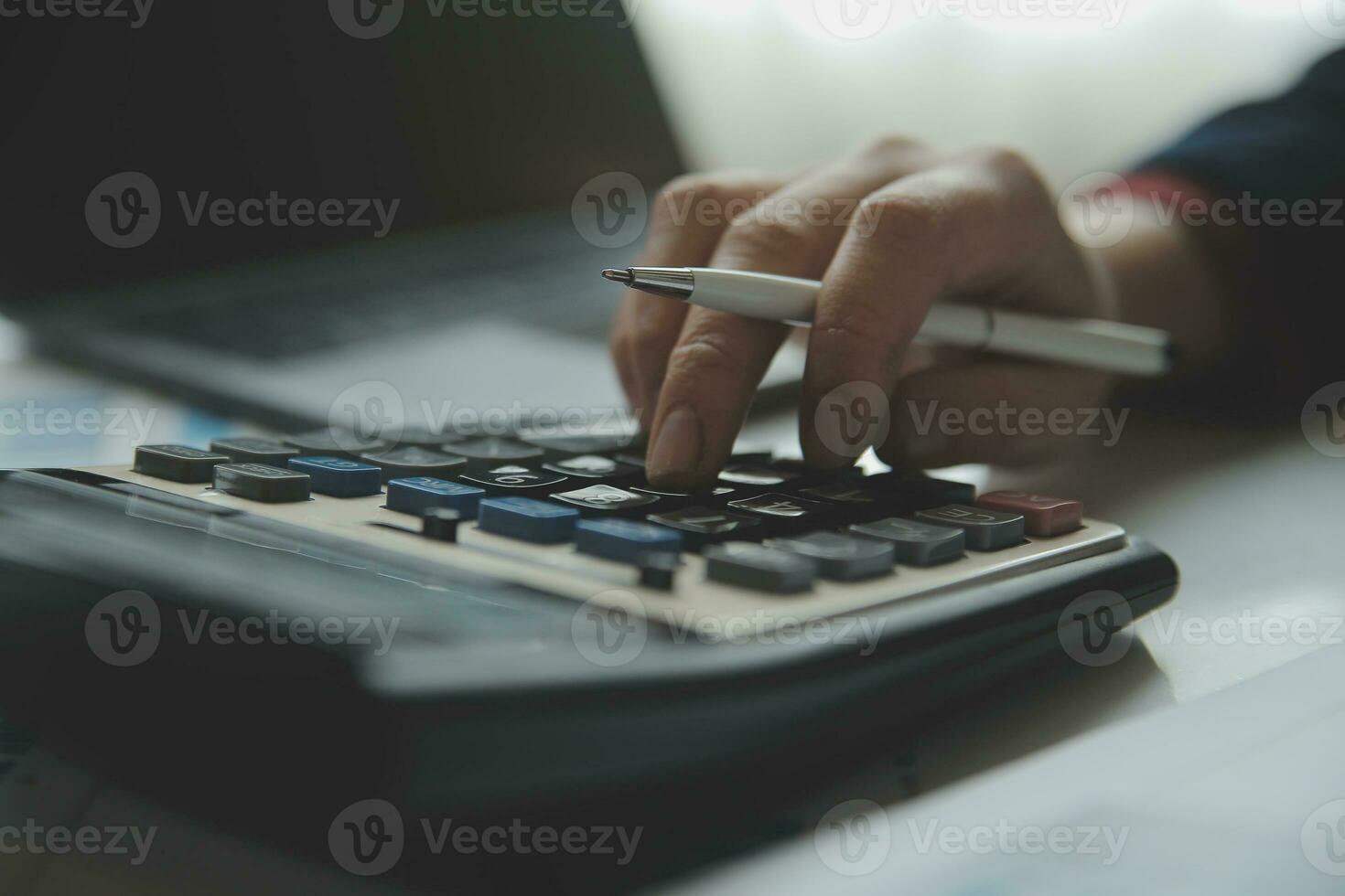 Unrecognizable businessman using calculator photo