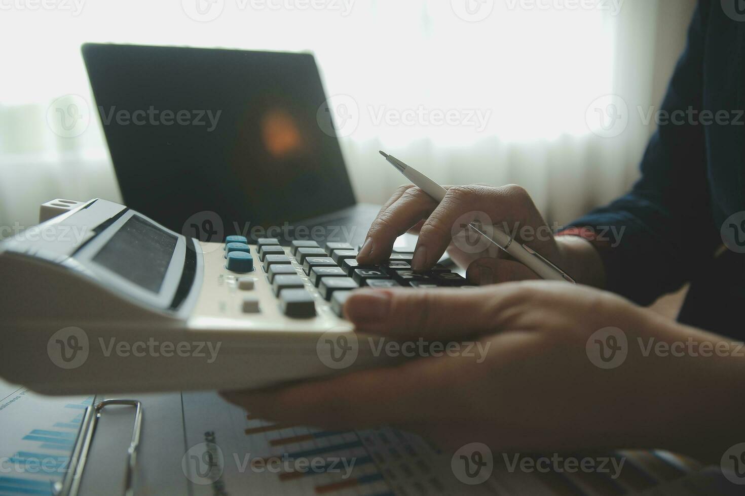 Unrecognizable businessman using calculator photo