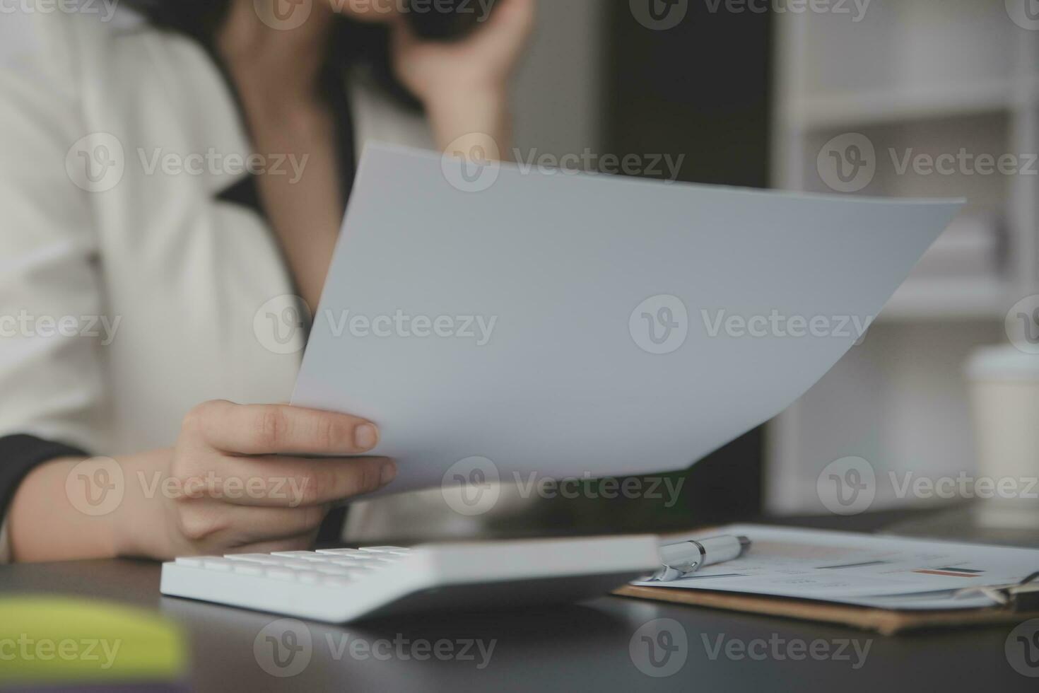 Asian Business woman using calculator and laptop for doing math finance on an office desk, tax, report, accounting, statistics, and analytical research concept photo
