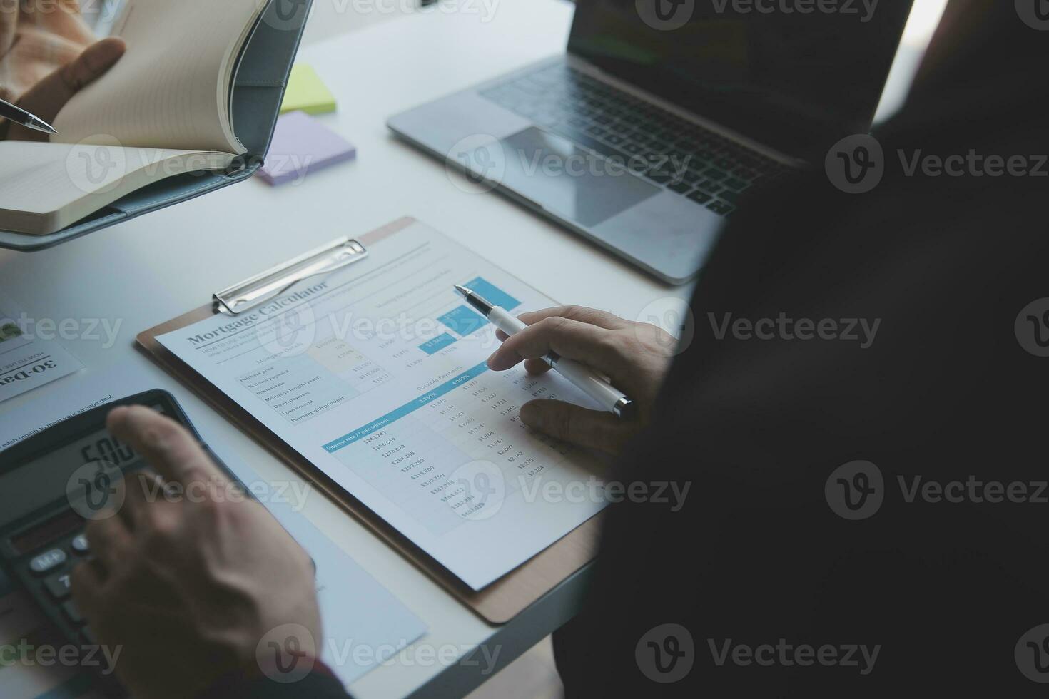 Asian Business woman using calculator and laptop for doing math finance on an office desk, tax, report, accounting, statistics, and analytical research concept photo
