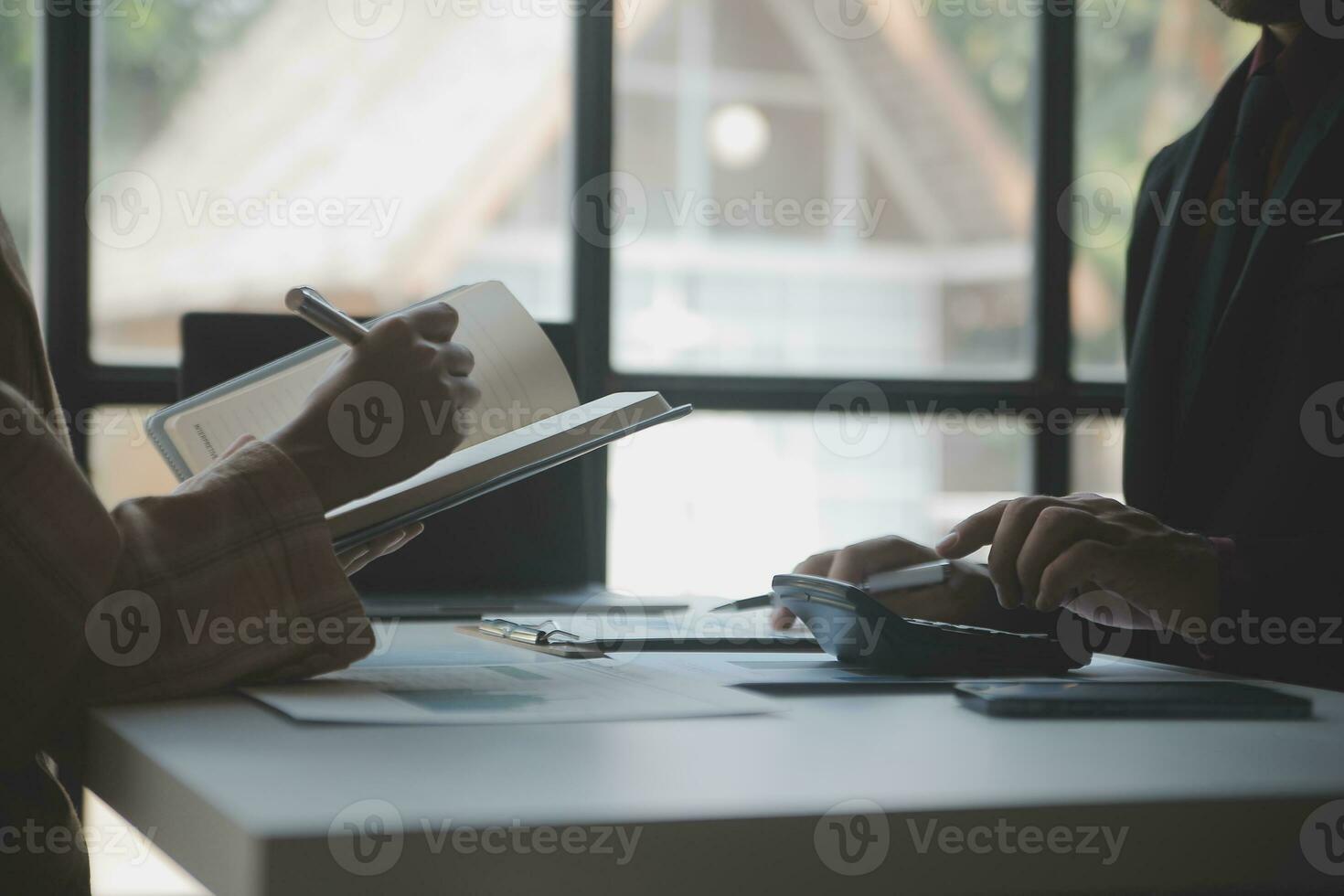 Asian Business woman using calculator and laptop for doing math finance on an office desk, tax, report, accounting, statistics, and analytical research concept photo