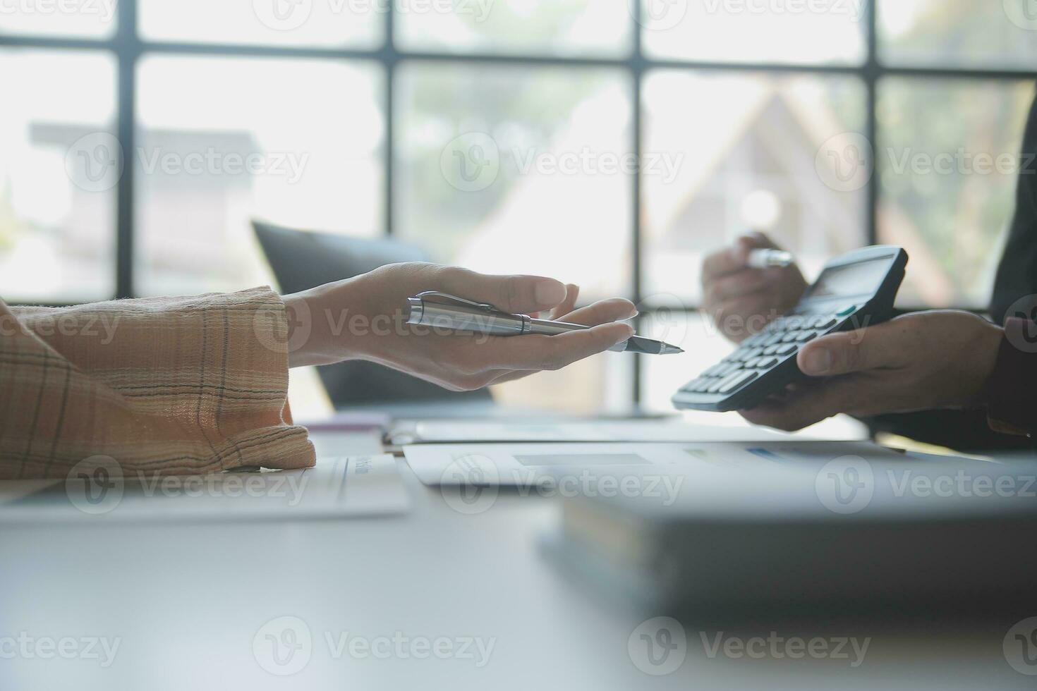 Asian Business woman using calculator and laptop for doing math finance on an office desk, tax, report, accounting, statistics, and analytical research concept photo