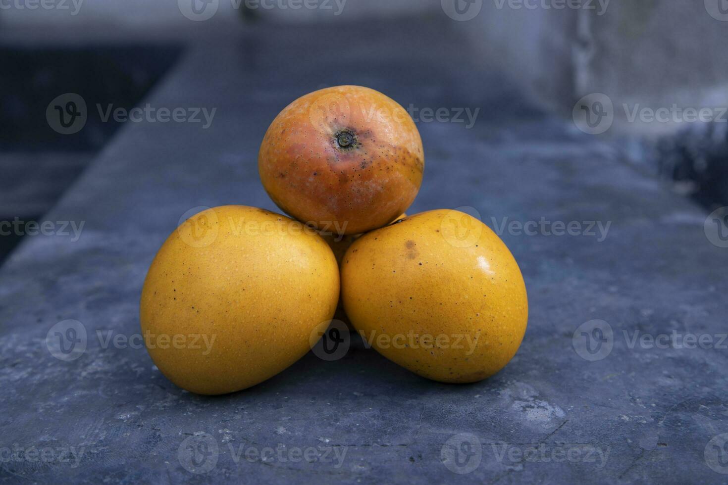 Ripe mangoes on a black stone background. Selective focus photo